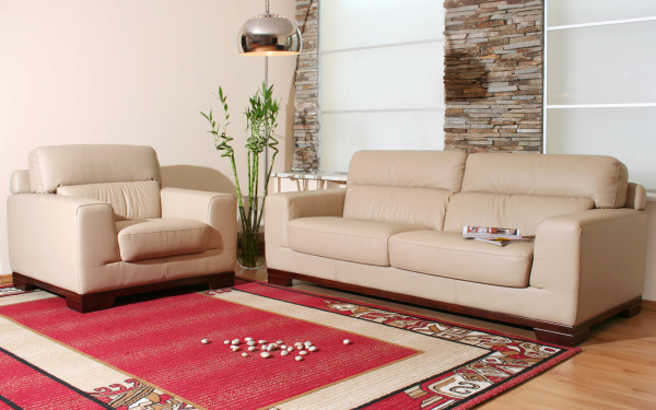 Furniture,Enthralling Brick Stone Wall Sofa For Small Living Room Decoration With Comfortable Two Beige Leather Sofa And Soft Red Area Rug On Combined Nice Bright Wood Floor Also Cool Glass Potted Plant Plus Beautiful Stainless Pendant Lamp,The Most Convenient Sofas For Small Living Rooms