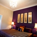Interior,Exquisite Dark Purple Mixed Cream Wall Bedroom Painting Ideas With Stylish Black Leather Blanket And Nice Brown Wood Nightstand Tables On Combined Beautiful Cream Table Lamps Shade Also Gorgeous White Crystal Chandelier,Creative Bedroom Painting Ideas