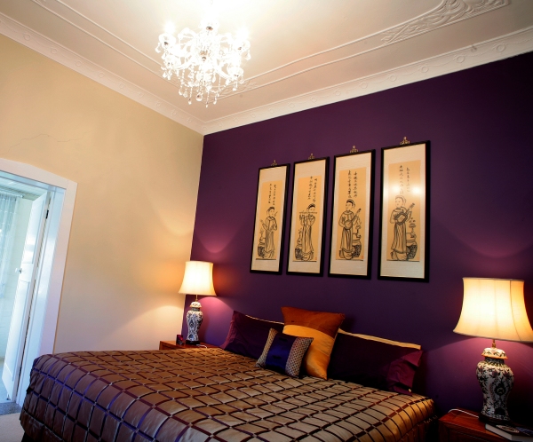 Interior,Exquisite Dark Purple Mixed Cream Wall Bedroom Painting Ideas With Stylish Black Leather Blanket And Nice Brown Wood Nightstand Tables On Combined Beautiful Cream Table Lamps Shade Also Gorgeous White Crystal Chandelier,Creative Bedroom Painting Ideas