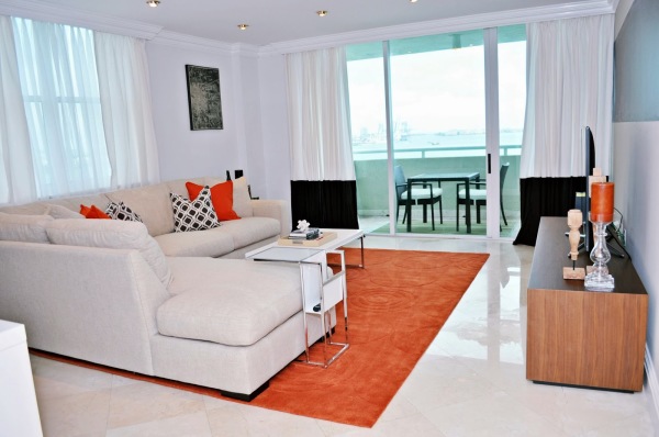 Apartments,Stunning White Themed Bachelor Apartment Design Inspiration With Wonderful White Sectional Sofa And Modern White Coffe Table On Combined Soft Orange Area Rug Also Amazing Great Glass Windows Plus Gorgeous White Curtains,Exceptional Bachelor Apartment Designs