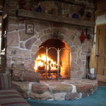 Interior,Rustic Stone Fire Places Design Ideas With Stylish Light Brown Stone Dorm Firaplace And Nice Brown Wood Wall Mount Shelf Also Comfortable Colorful Striped Sofa Plus Soft Large Blue Carpet,The Beauty Of Stone Fire Places Your Home Inspiration
