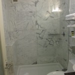 Furniture,Enthralling White Mixed Black Granite Wall Panel Shower Design Small Bathroom With Wonderful White Shower Pan And Nice Glass Door Shower Also Comfortable White Ceramic Closet Seat For Modern Concept,Modern Shower Designs Small Bathrooms