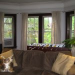 Furniture,Enchanting Gray Wall Paint Bay Window Decorating With Cool Brown Fabric Three Seater Sofa On Combined Soft Pillows And Gorgeous Black Wood Window Frame Also Nice Cream Curtians,Contemporary Bay Window Decorating