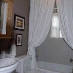 Apartments,Delightful Bathroom Design For Apartement With Wonderful White Ceramic Bathtub And Beautiful White Curtains Also Comfortable White Closet Seat Plus Gorgeous Cream Vanity Light,Gorgeous Small Space Bathroom Designs For Apartments
