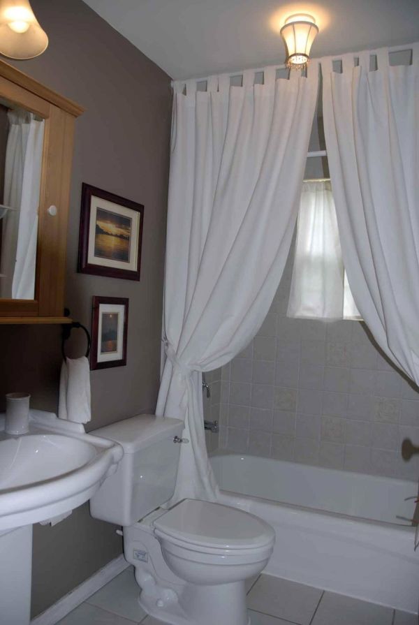 Apartments,Delightful Bathroom Design For Apartement With Wonderful White Ceramic Bathtub And Beautiful White Curtains Also Comfortable White Closet Seat Plus Gorgeous Cream Vanity Light,Gorgeous Small Space Bathroom Designs For Apartments