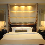 Bedroom,The Best Small Designer Bedroom With Stylish White Bed Sheet And Beautiful White Leather Large Headboard Also Trendy Black Nightstand Tables On Combined Adorable Table Lamps Plus Gorgeous Vertical Wall Mirrors For Elegant Concept,The Best Modern Small Designer Bedrooms
